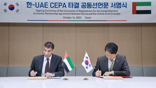 안덕근 산업통상자원부 통상교섭본부장이 14일 오후 서울 중구 대한상공회의소에서 타니 빈 아흐메드 알 제유디 아랍에미리트(UAE) 경제부 대외무역 특임장관과 한-UAE 포괄적경제동반자협정(CEPA) 타결 공동선언문에 서명하고 있다. 연합뉴스